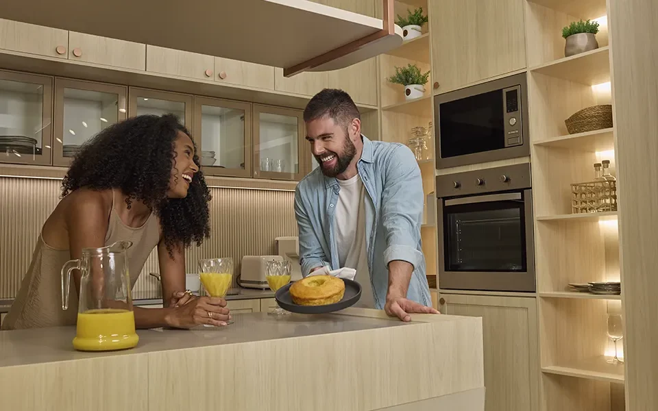 Mulher e homem sorrindo em uma cozinha planejada