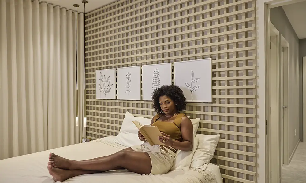 Mulher sentada na cama lendo um livro