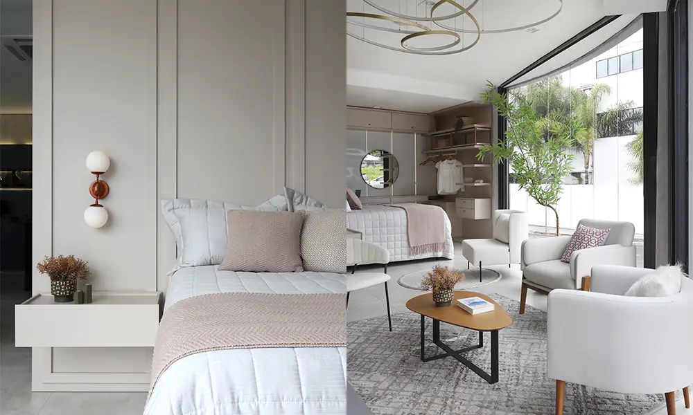 Suíte moderna e elegante com cama em tons neutros, iluminação decorativa, área de estar com poltronas e mesa de centro, armário aberto e ampla janela com vista para área externa com plantas.